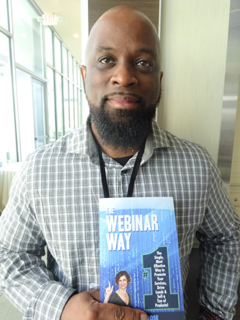 Korby Waters holds The Webinar Way book by Sherrie Rose